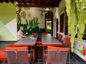 a man sitting at a table in a restaurant at Tropicana La Catedral in Antigua Guatemala