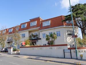 a white building with a red roof on a street at Sea Road Apartments in Bournemouth