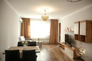 a living room with a dining table and a television at Apartments Rivera in Dobrich +9 photos