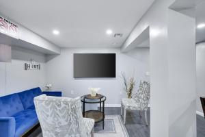 a living room with a blue couch and a tv at 4BR Newark Stay w/ Parking And Fast Wi-Fi in Newark