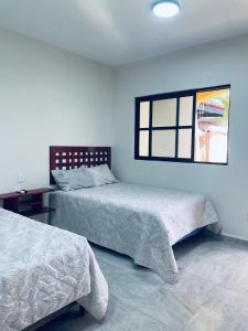 a bedroom with two beds and a window at Hotel Villa Chucum in Valladolid