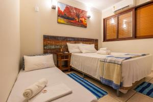 a bedroom with two beds and a window at Delphin Beach Hotel - Suíte 238 in Guarujá +26 photos