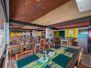 a restaurant with tables and chairs in a room at Delphin Beach Hotel - Suíte 238 in Guarujá