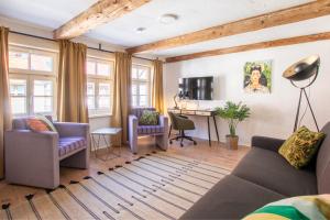 a living room with a couch and chairs and a desk at Bergsonnen-Stuben in Bad Lauterberg