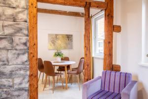 a table and chairs in a room with a stone wall at Bergsonnen-Stuben in Bad Lauterberg