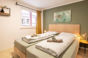 two beds in a bedroom with towels on them at Bergsonnen-Stuben in Bad Lauterberg