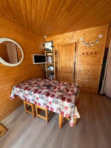a room with a table in a wooden cabin at Duplex cosy jusqu'à 6 personnes- chalet des Pléiades - départ skis aux pieds en bordure de piste sans portage - au milieu des fleurs en été - l'autre duplex du chalet est également à nous in Risoul