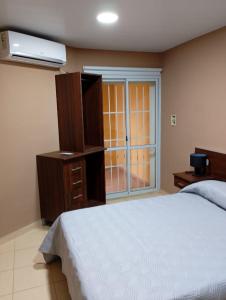 a bedroom with a bed and a dresser and a window at Departamentos 12 de Mayo in Salsipuedes