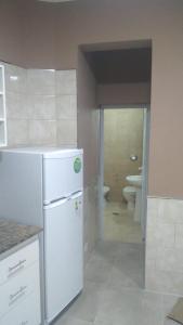 a kitchen with a white refrigerator and a bathroom at Departamentos 12 de Mayo in Salsipuedes