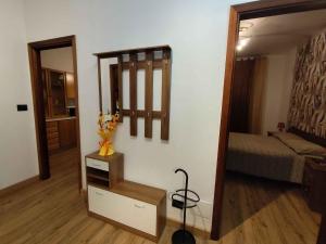 a room with a mirror and a bedroom with a bed at La Casa dello Zio Pollo in Dogliani