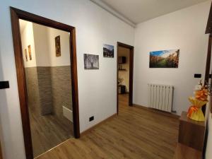 a hallway with a mirror and paintings on the wall at La Casa dello Zio Pollo in Dogliani