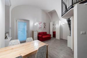 a living room with a red couch and a red chair at Monolocale Piazza Garibaldi in Saluzzo