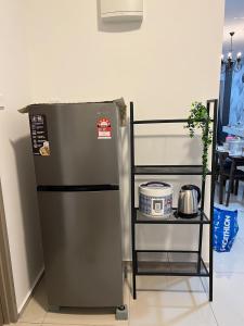 a refrigerator next to a shelf in a kitchen at Cloud9 Homestay D Aman Residence in Alor Setar