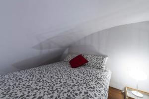a bedroom with a bed with a red pillow at Monolocale Piazza Garibaldi in Saluzzo