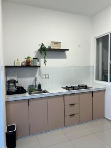 a white kitchen with a sink and a stove at Cloud9 Homestay D Aman Residence in Alor Setar +9 photos