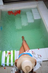 a woman laying on a towel in a swimming pool at Ndare Eco Ville in Kigali