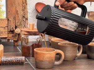 a person is pouring coffee into a cup at Umbral Habitación Rústica con Desayuno Incluido in Tepoztlán +30 photos