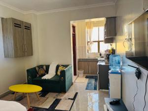 a living room with a couch and a kitchen at Bella apartment studios town in Meru