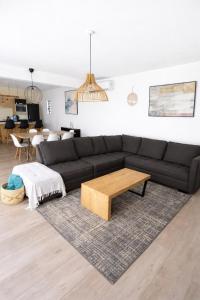 a living room with a black couch and a coffee table at Villa Marea Private Pool in Grand Baie with garden, BBQ & Parking in Grand-Baie +32 photos