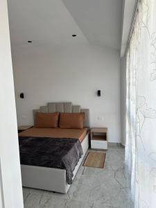 a bedroom with a bed and a white wall at Qyteza guest house in Shkodër