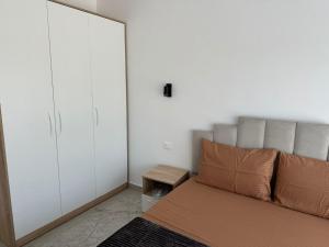 a bedroom with a bed and white cabinets at Qyteza guest house in Shkodër