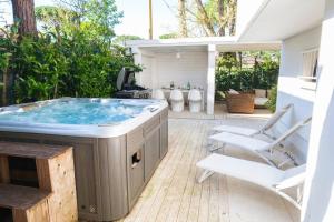 a jacuzzi tub in a patio with a chair at Villa Irene in Cervia