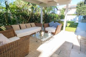 a patio with wicker furniture and a glass table at Villa Irene in Cervia