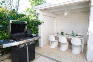 a patio with a table and chairs and a grill at Villa Irene in Cervia +37 photos