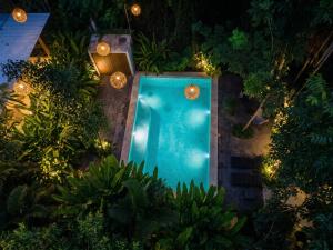 an overhead view of a swimming pool at night with lights at Yaakun in Bacalar +26 photos