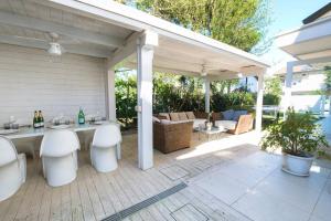 a patio with white stools and a table with bottles at Villa Irene in Cervia