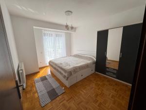 a bedroom with a bed and a dresser and a mirror at Sonny Penthouse 2 in Gnjilane
