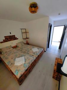 a bedroom with a bed with a comforter on it at Casa MATEO in Topliţa