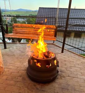 a fire pit on a patio with a bench at Casa MATEO in Topliţa