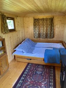 a bedroom with a bed in a wooden house at Cirkusz Udvar in Kapolcs