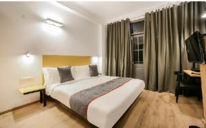 a hotel room with a large bed and a desk at Hotel Shree Jee in Gurgaon