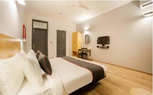 a bedroom with a white bed and a television at Hotel Shree Jee in Gurgaon