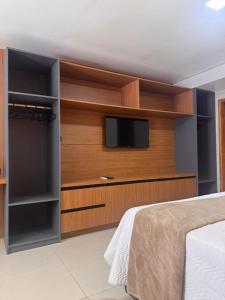 a bedroom with a flat screen tv and a bed at Uruguaiana House in Uruguaiana