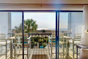 a balcony with tables and chairs and a view of the ocean at La Mare Vita in Carolina Beach