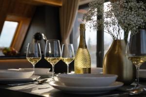 a table with wine glasses and a bottle of wine at CHATAR Tatra Premium Suites in Zakopane