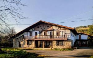 a large house with a balcony on top of it at Albergue Gerekiz AMAGI, exclusivo peregrinos in Flores