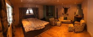 a bedroom with a bed and chairs in a room at Kvitfjell in Ringebu