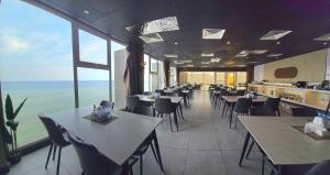 a restaurant with tables and chairs and the ocean at نزل رالين للنزل السياحية in Al Wajh