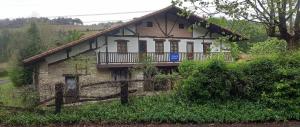 a house on a hill with a fence in front of it at Albergue Gerekiz AMAGI, exclusivo peregrinos in Flores +2 photos