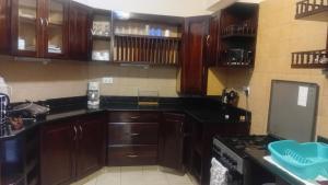a kitchen with wooden cabinets and a stove top oven at Palm breeze seafront shanzu in Shanzu