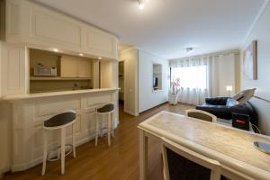 a kitchen and living room with a couch and a table at Victoria Place By HX in São Paulo