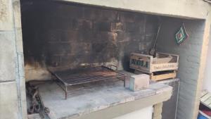 a brick fireplace with a grill and boxes on it at Lahogareña in La Cieneguita