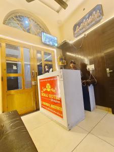 a hotel room with a sign in front of a refrigerator at The Miraj Hotel in Murthal