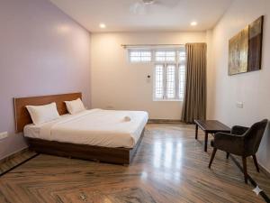a bedroom with a bed and a table and a chair at Heritage Inn Gomti Nagar in Lucknow +22 photos