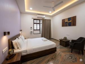 a bedroom with a bed and a desk and a chair at Heritage Inn Gomti Nagar in Lucknow