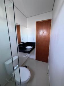 a bathroom with a toilet and a wooden door at Uruguaiana House in Uruguaiana +77 photos